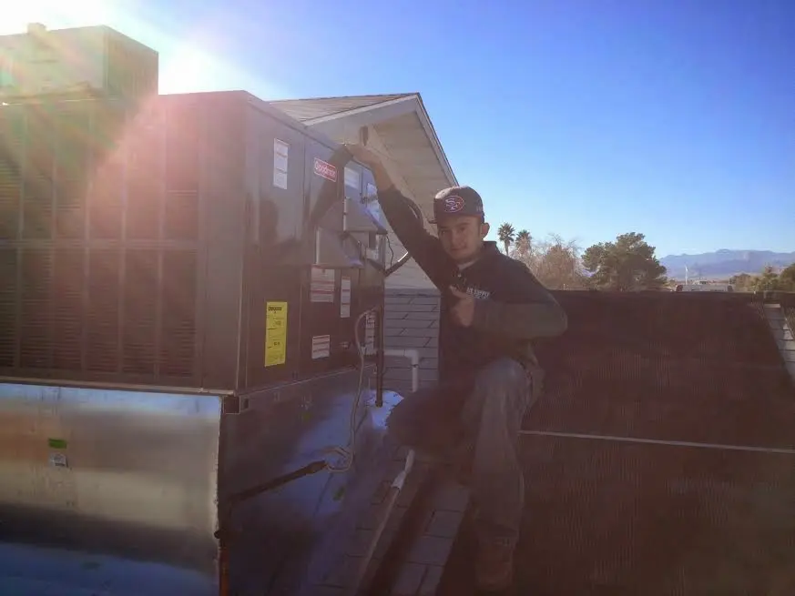 HVAC technician performing AC Tune-Up on a rooftop unit in La Vista